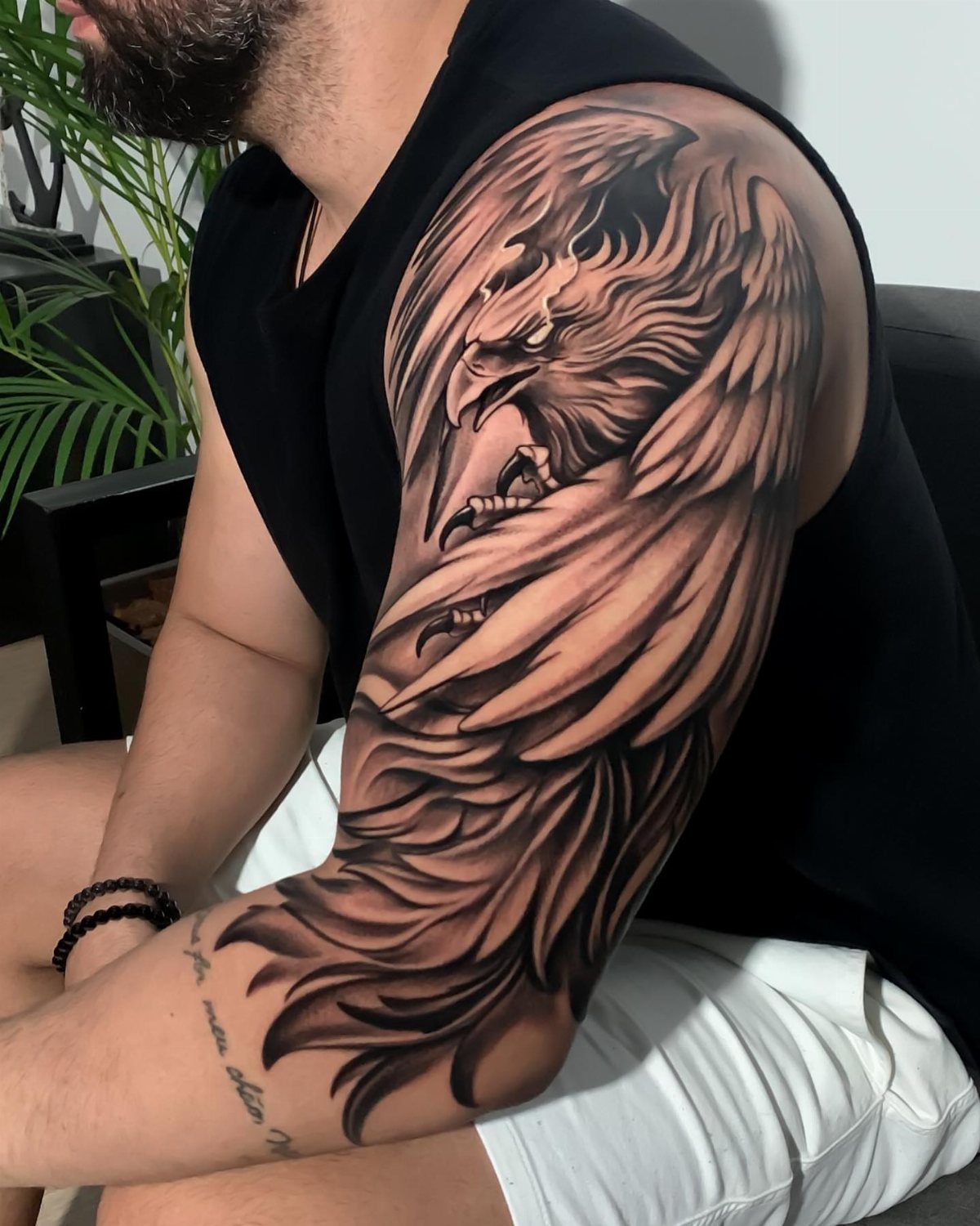 Detailed black and grey eagle tattoo covering a man's upper arm and shoulder.