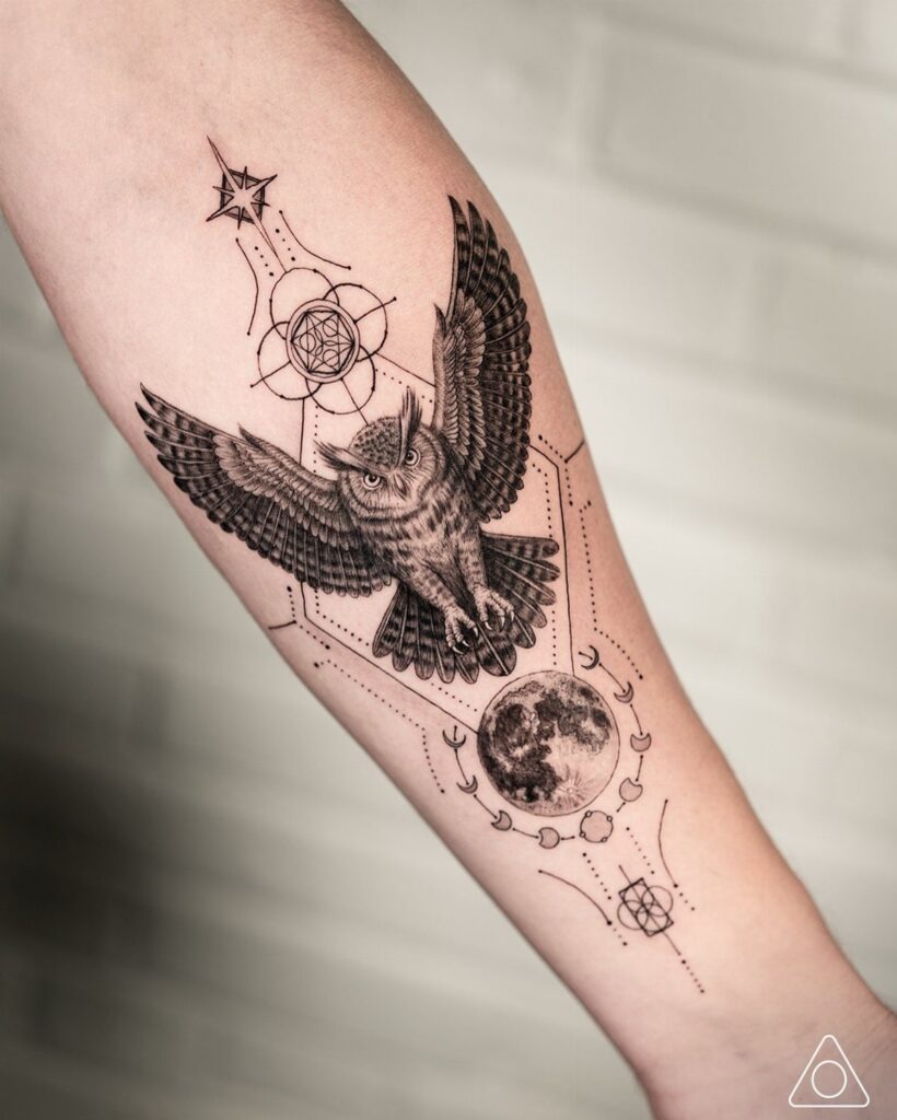 Inner forearm tattoo of an owl with a moon and geometric patterns.