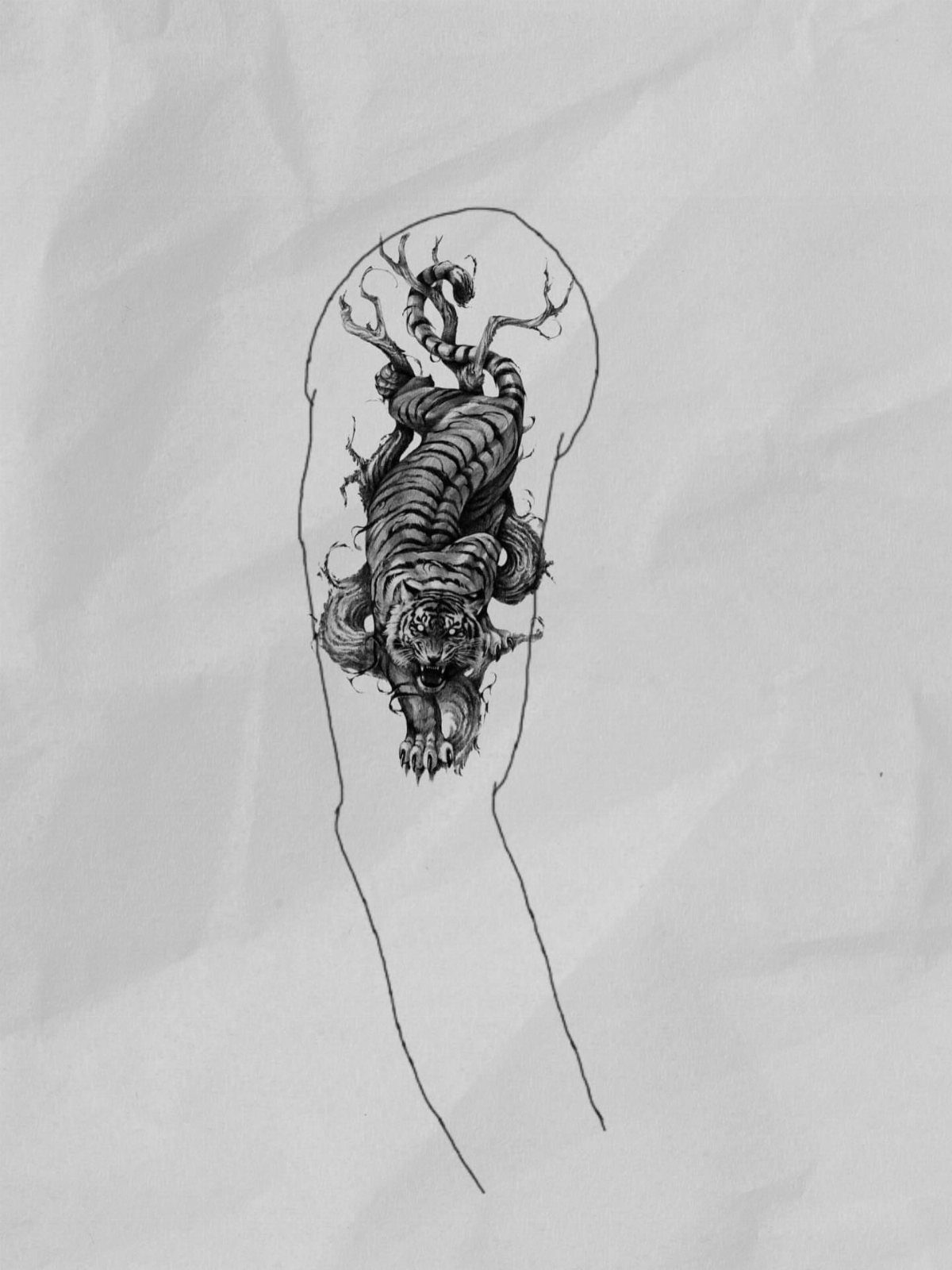 Monstrous creature tattoo design sketch on crumpled paper shaped like a human shoulder.