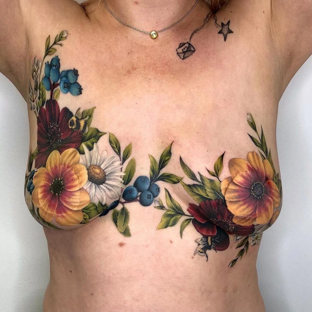 Colorful floral tattoos with yellow and red flowers on a person's chest.