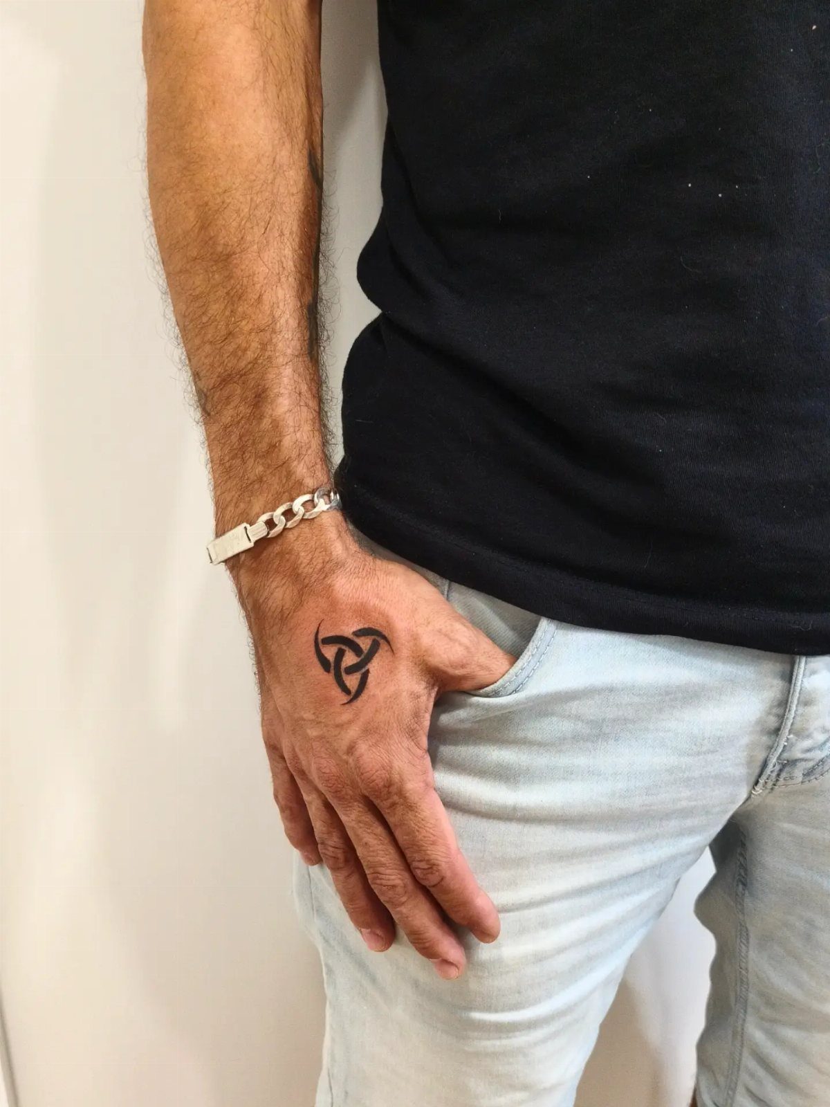 Triple Horn of Odin tattoo on the back of a man's hand